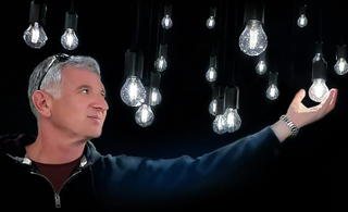 an image of Michael Barenboym surrounded by lit lightbulbs