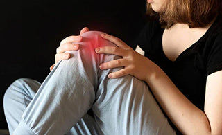 a woman holding her knee which is tinged red like it is in pain